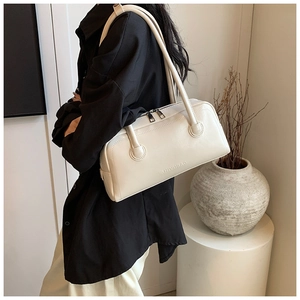Close-up of cream leather shoulder bag with silver double zippers and embossed logo