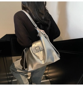 Détail du sac cabas argenté avec bandoulière, foulard décoratif et pendentif boule