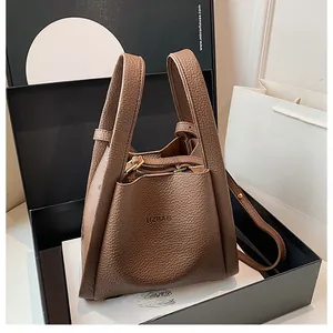 Close-up of brown litchi pattern leather bucket bag with UZBAG logo and metal buckle detail