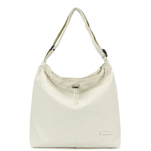 Gros plan d'un sac à bandoulière en nylon crème avec détails à cordon et logo