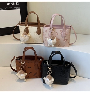 Detail of colorful embossed bucket bags with plush monster charms and brand text