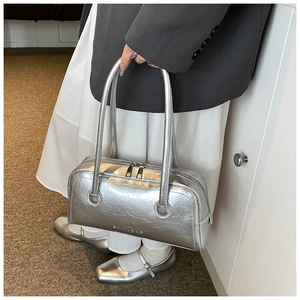 Close-up of metallic silver baguette bag with wrinkled PU leather and dual zippers