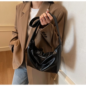Close-up of black leather hobo bag showing fine texture and vertical stitching details