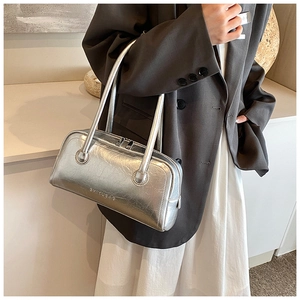 Close-up of metallic silver bowling bag with brand logo and soft pleated leather detail