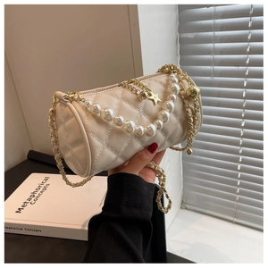 Close-up of quilted cream cylinder bag with pearl handle and star metal charm detail