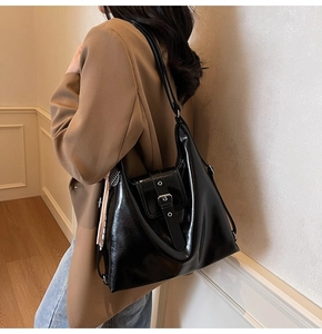Détail du sac cabas noir brillant avec rabat à boucle décorative et écharpe en soie chic