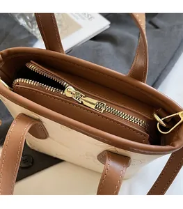 Close-up of golden metal zipper and embossed texture on color-block bucket bag
