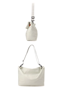 Détail du sac cabas minimaliste en toile crème avec ferrures noir mat et large bandoulière