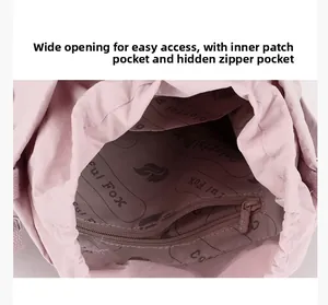 Detail view of pink nylon bag interior featuring zipper pocket and drawstring closure