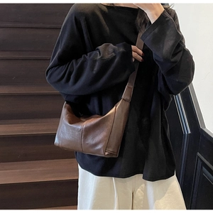 Detailed view of a dark brown half-moon crossbody bag with minimalist seam detailing