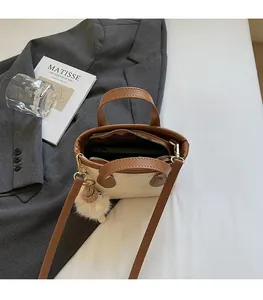 Internal view of cream and brown crossbody bucket bag showing spacious phone storage