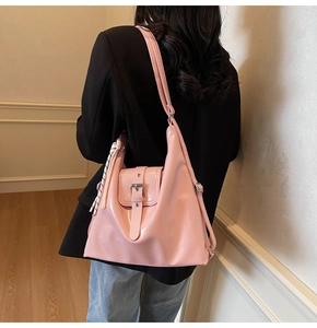 Détail d'un sac cabas en cuir verni rose avec un foulard décoratif sur la bandoulière