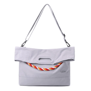 Détail d'un sac bandoulière en nylon gris clair avec corde bicolore et boucle métal