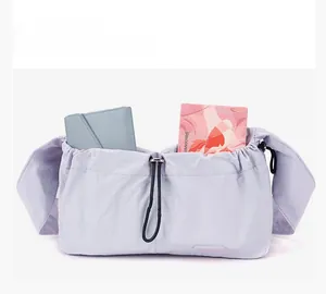 Close-up of lilac nylon shoulder bag featuring double front drawstring pockets and logo