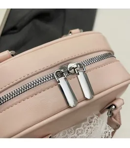 Detail van de roze lederen bowlingtas met gladde zilveren dubbele metalen ritssluiting