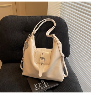 Grand sac fourre-tout beige chic posé sur une chaise en velours côtelé