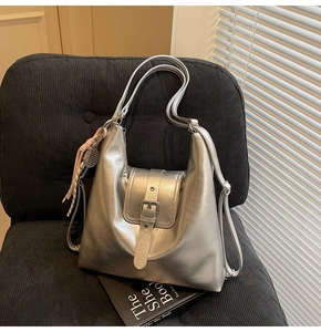 Sac hobo métallisé argenté sur canapé avec breloque raquette de tennis et boucle