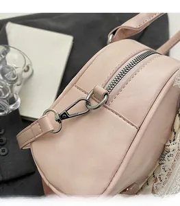 Detailed macro view of light pink bag featuring silver metal zipper and swivel hardware
