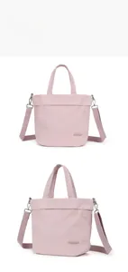 Detail view of pink nylon shoulder bag showing handles and adjustable crossbody strap