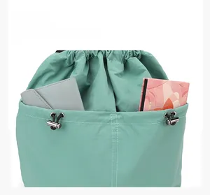 Detail view of mint green drawstring backpack side pocket with nylon fabric texture