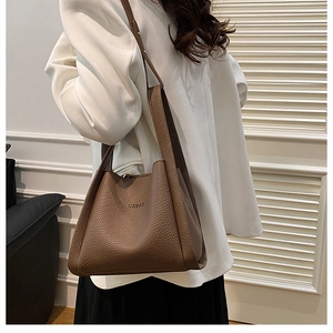 Brown lychee texture leather bucket bag shown on model for size and style reference