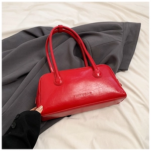 Detailed macro view of red glossy leather texture and SHIYUBAG logo on a baguette bag
