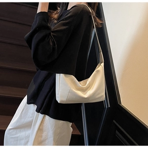 Detail of white soft leather dumpling bag showing fine texture and stylish shoulder drape