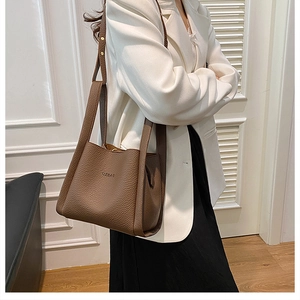 Close-up of premium brown leather bucket bag with UZBAG logo and adjustable strap