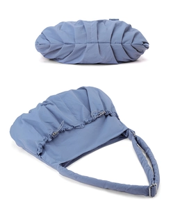 Detail of blue nylon cloud tote bag featuring pleated drawstring texture and metal buckle