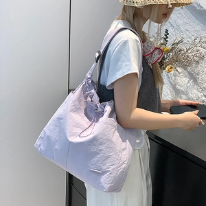 Détail du sac cabas lilas montrant le tissu en nylon froissé et la large bandoulière
