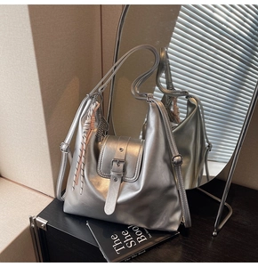 Détail du sac hobo argenté avec boucle de ceinture et pendentif en corde tressée