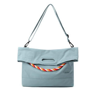 Détail du sac bandoulière en nylon bleu clair avec poignée en corde tressée