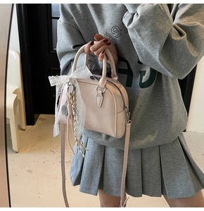 Detail of pink PU leather bowling handbag with lace bow and mini tennis racket charm