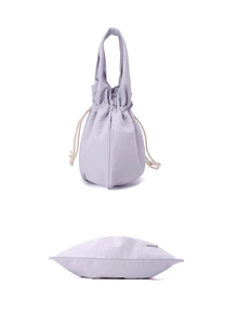 Detail view of water-resistant light purple nylon drawstring handbag with soft fabric texture