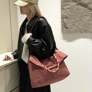 Détail du sac cabas en nylon corail avec poignée tissée colorée et bandoulière large
