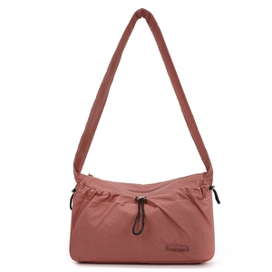 Detail of dusty rose nylon shoulder bag featuring ruched drawstring and wide strap