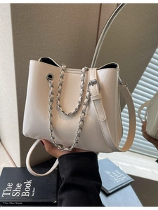Cremeweiße glänzende Leder-Eimertasche mit silberner Kette und praktischem Tragegriff