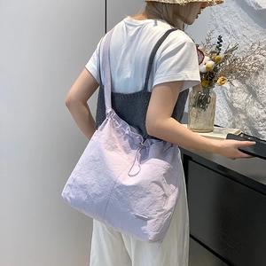 Vue détaillée du sac à bandoulière lilas avec cordon et texture en nylon plissé