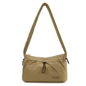 Detail of khaki green nylon shoulder bag showing pleated drawstring pocket and fabric texture