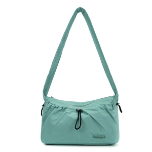 Close-up of mint green nylon shoulder bag featuring black drawstring and brand logo