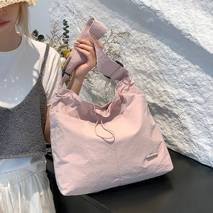 Détail du sac à bandoulière rose clair avec cordon et sangle réglable pour femme
