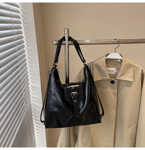 Détail du cabas en cuir PU noir brillant avec boucle argentée et finition métallique