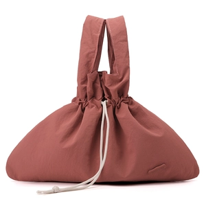 Detail of dusty rose nylon handbag featuring ruched texture and white drawstring closure