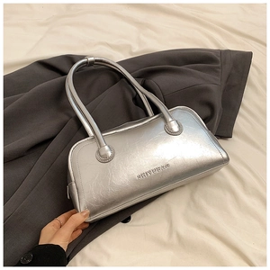 Detail of silver metallic Boston bag with textured finish and brand embossing