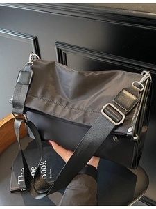 Minimalist black nylon crossbody tote bag with adjustable wide strap and silver hardware