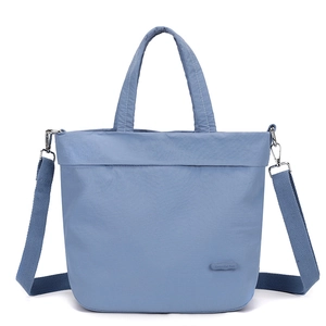 Detail of light blue nylon tote bag with Colorful Fox logo and woven shoulder strap