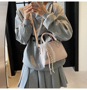 Pink bowling bag with white lace trim and adjustable strap shown in a mirror selfie