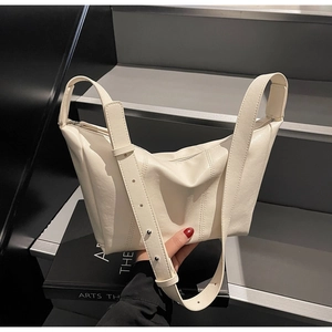 Detail of a creamy white PU leather crescent bag with adjustable wide shoulder strap