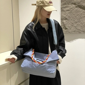 Détail du sac cabas bleu clair avec poignées en corde tissée et large bandoulière