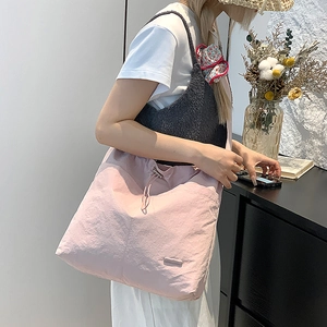 Détail du sac cabas en nylon rose cerise avec fermeture à cordon et fini texturé